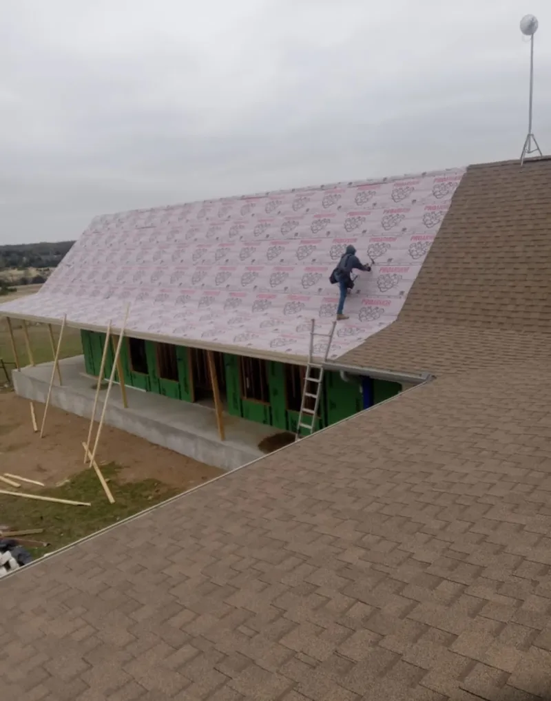 Worker preparing underlayment for a metal roof installation in Philadelphia
